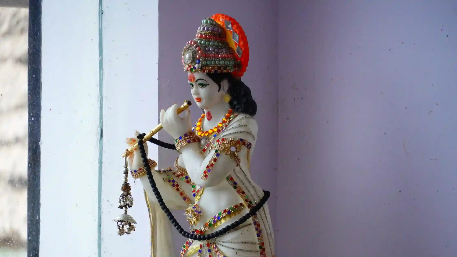 Idol of Lord Krishna adorned with jewelry, representing Lord Natavara Aarti in a serene setting