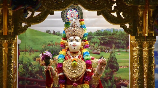 Lord Satyanarayana Aarti performed in front of a beautifully adorned deity surrounded by vibrant flowers