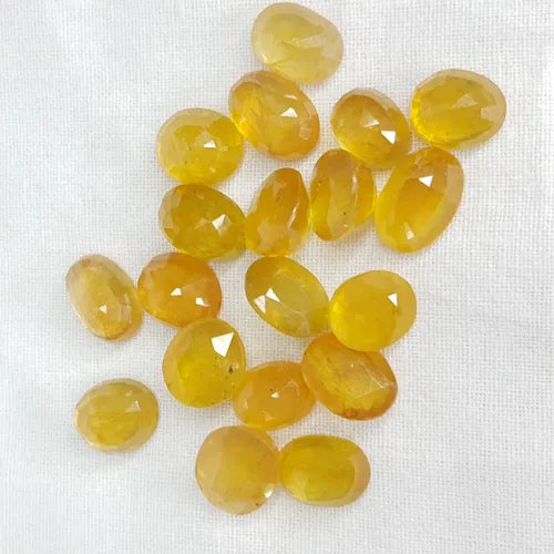 Collection of Yellow Sapphire Stones in various shapes and sizes, showcasing their brilliant color and clarity