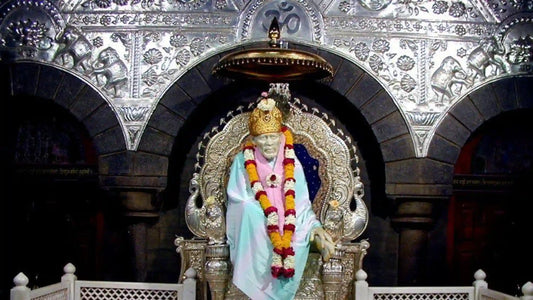 The statue of Sai Baba adorned with flowers and a crown during a prayer ceremony for Sai Baba Aarti