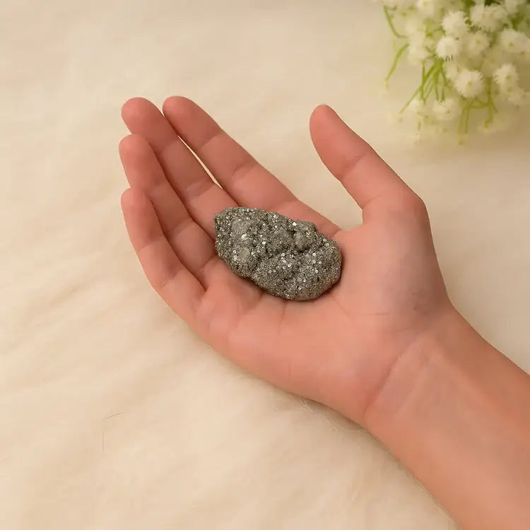 RudraGram certified pyrite gemstone displayed in a hand with a soft background