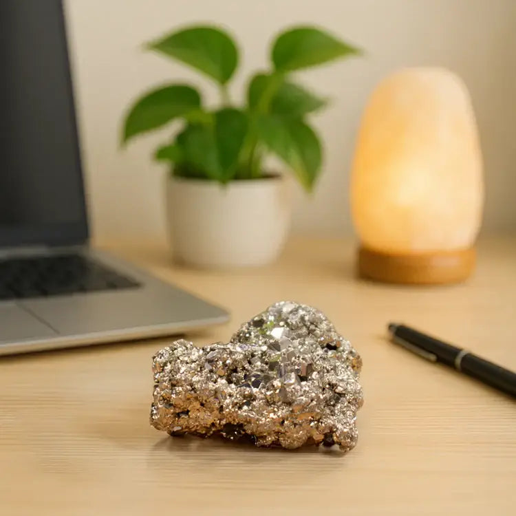 RudraGram certified pyrite gemstone displayed on a desk with a plant and lamp in the background