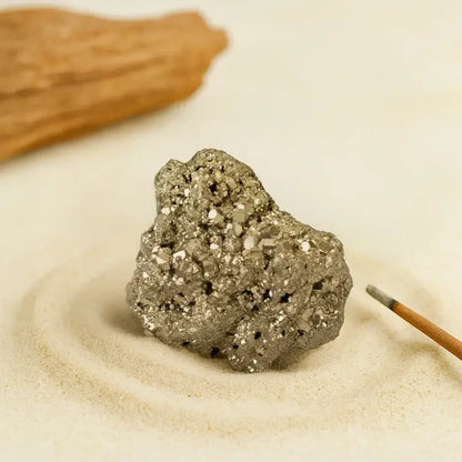 RudraGram certified pyrite gemstone with natural sparkle and unique texture on a sandy background